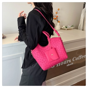 Detail of vibrant pink tote bag with embossed clover patterns and mini coin purse
