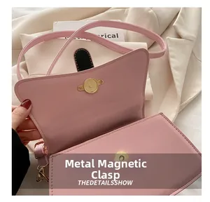 Detail of the premium gold magnetic snap closure on a pink textured leather handbag