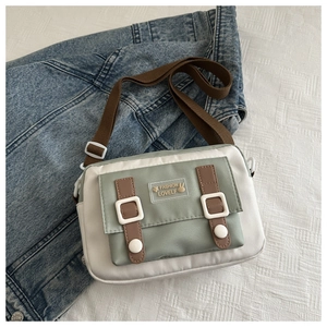 Detail van de minimalistische nylon crossbodytas met tweekleurig patchwork en riem