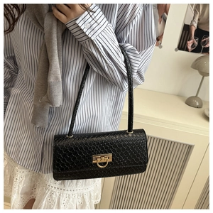 Close-up of black woven shoulder bag featuring a signature golden metal G-lock closure