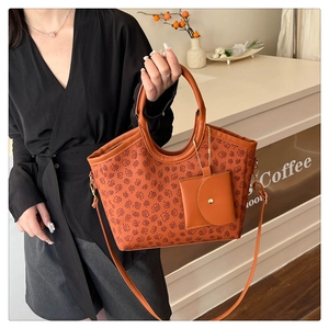Close-up of brown floral tote bag with matching mini pouch and adjustable strap