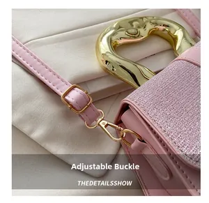 Detail of pink crossbody bag with sparkling fabric, golden handle and adjustable buckle