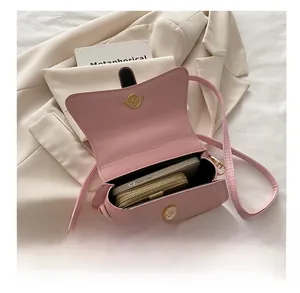 Interior view of pink glossy leather crossbody bag showing space for phone and wallet