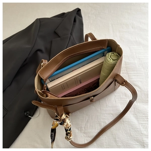 Vue détaillée du sac cabas en cuir marron avec surpiqûres blanches et foulard en soie