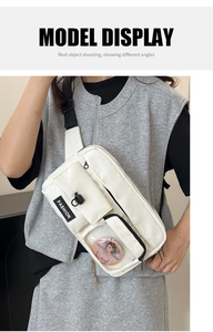 Close-up of white crossbody bag with multi-pocket design and clear badge window