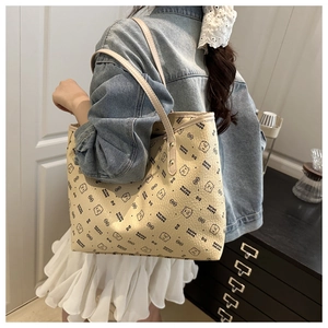 Detailed view of beige tote bag with black bear print worn by model for daily outfit