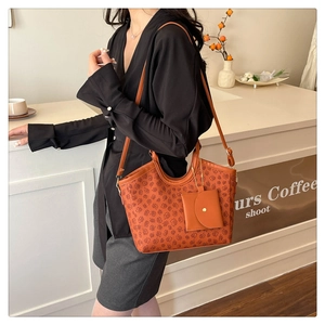 Floral print tote bag with adjustable strap and matching small pouch in coffee shop