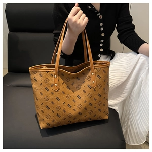 Close-up of brown faux leather tote bag showing cartoon bear pattern and gold metal hardware