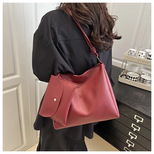 Dettaglio della borsa tote bordeaux con tracolla annodata e mini pochette coordinata