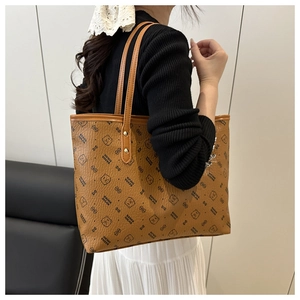 Detail of brown tote bag featuring cartoon bear prints and textured leather grain finish