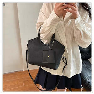 Detail of black embossed PU leather tote bag with round handles and mini coin pouch