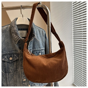 Close-up of brown corduroy hobo bag with moon shape and silver metal zipper detail