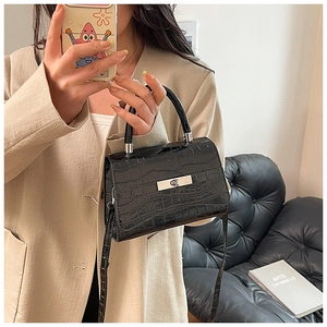 Detail of black crocodile texture bag with silver buckle and elegant top handle