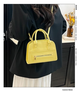 Detailed shot of yellow Boston bag showing lychee grain texture and metal zipper