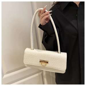 Close-up of white crocodile pattern shoulder bag with a gold D-shaped metal clasp