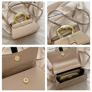 Detail view of apricot crossbody bag with unique gold metal handle and interior storage