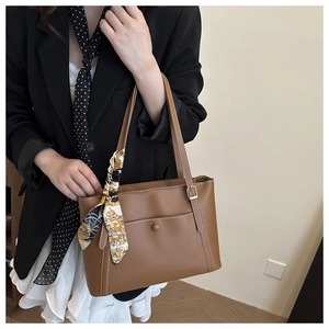 Borsa tote marrone in ecopelle con foulard di seta e tasca esterna indossata da modella
