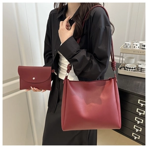 Dettaglio del set di borse in pelle PU bordeaux con pochette coordinata e tracolla con nodo