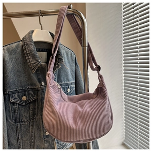 Detail of lavender corduroy crescent bag showing its soft ribbed texture and silver zipper