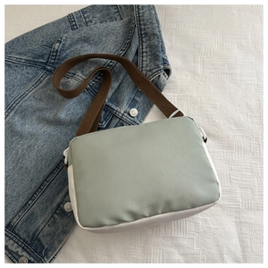 Detail of light green and white nylon crossbody bag with adjustable brown strap