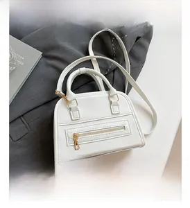 Detailed macro of white litchi pattern leather bag featuring gold zipper accents