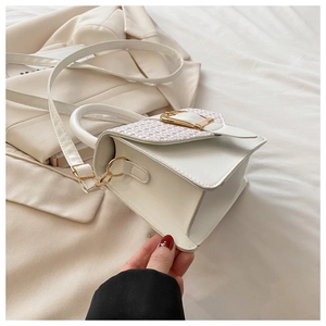 Détail du sac bandoulière blanc avec rabat tissé et fermoir métallique doré élégant