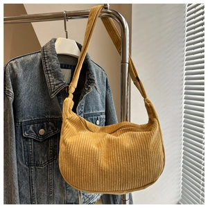 Detail of ginger yellow corduroy crescent bag showing soft ribbed texture and wide strap