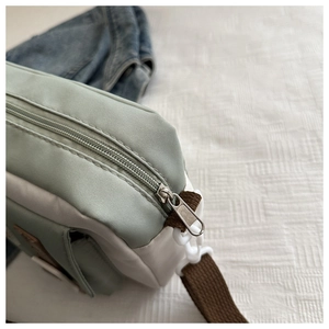 Detail of the high-quality zipper and durable woven strap on a nylon crossbody bag