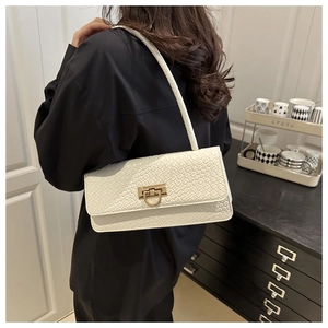 Detail of creamy white woven texture handbag with elegant gold U-shaped metal buckle