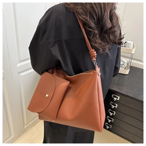 Dettaglio della borsa tote marrone con tracolla annodata e pochette coordinata inclusa