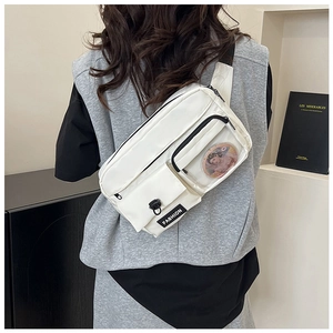 Detail of white crossbody bag featuring functional compartments and transparent window