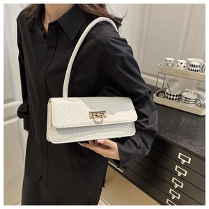 Detail of white woven texture shoulder bag with gold metal buckle on a black shirt