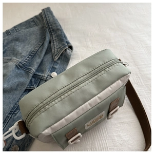 Detail of a nylon crossbody bag with color blocking design and adjustable woven strap