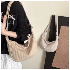 Detailed close-up of cream corduroy texture and hobo style strap on the shoulder bag