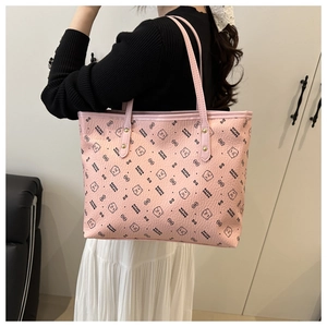 Detailed view of pink leather tote bag with bear pattern and gold metal rivets