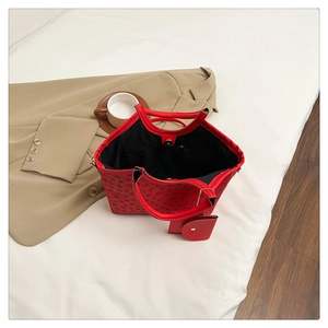 Macro view of red monogram tote bag interior with inner zipper pocket and mini purse