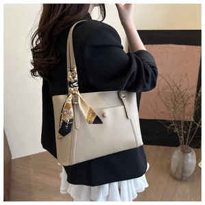 Dettaglio della borsa tote in pelle grigia con foulard decorativo e tasca magnetica