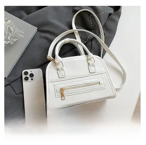Detailed comparison of white lychee leather handbag size with a modern smartphone