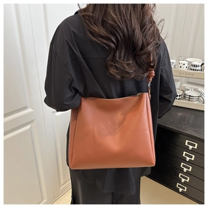 Borsa tote marrone indossata da una modella con dettaglio unico del nodo sulla tracolla