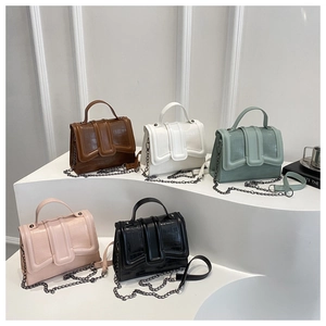 Cinq sacs à main en crocodile avec chaînes métalliques en plusieurs couleurs sur socle