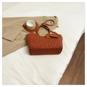Classic large tote bag with clover print and small pouch on minimalist white bed background