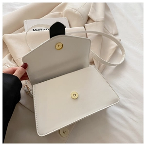 Vue détaillée du sac bandoulière blanc avec boucle magnétique dorée et intérieur