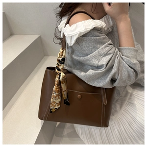 Grand sac cabas marron en similicuir avec foulard décoratif porté par un mannequin