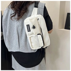 Detailed back view of a white nylon crossbody bag with multi-pocket design on model