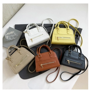 Macro shot showing five colors of pebbled leather tote bags with zipper details