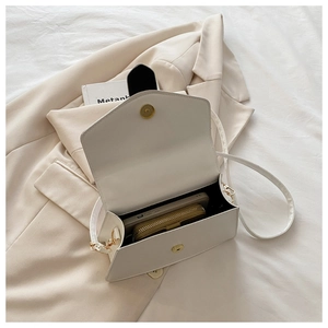 Vue intérieure du sac bandoulière blanc avec portefeuille marron et téléphone