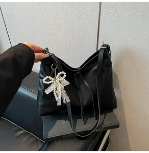 Detail der schwarzen Shopper Tasche mit Perlen-Schleife, Spitze und Fransen