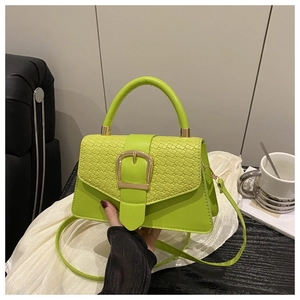 Détail du sac bandoulière vert citron avec rabat texture croco et boucle dorée élégante