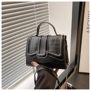 Détail de la texture cuir à motif crocodile noir sur un sac à main à chaîne élégant