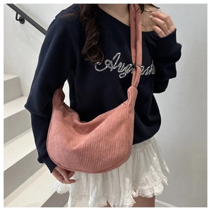 Detailed texture of pink corduroy crescent crossbody bag with wide shoulder strap